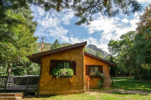 una pequeña casa con flores en la ventana en The Creekside Cabin at La Caille, en Sandy