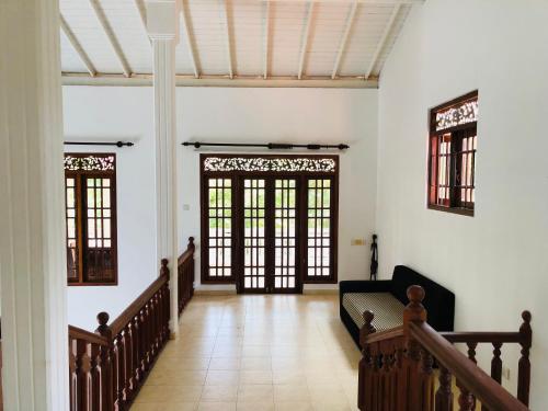 einen Flur mit zwei großen Türen und einer Treppe in der Unterkunft Hikka Villa in Hikkaduwa