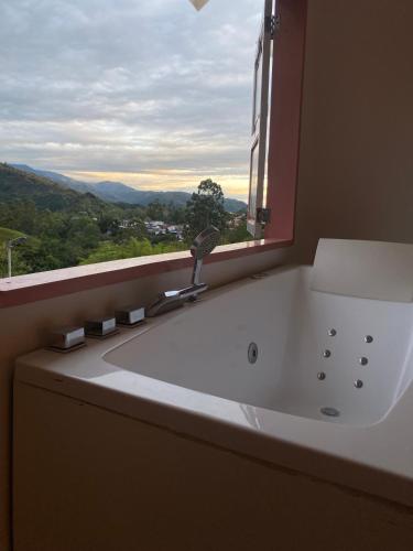 a white bath tub in a bathroom with a window at Mahalo Hostel in Salento
