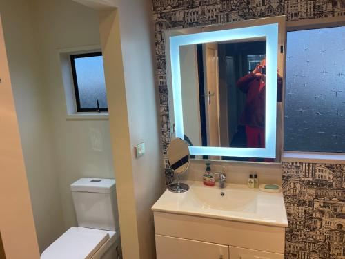 a person taking a picture of a bathroom with a mirror at Kaiapoi Village House in Kaiapoi