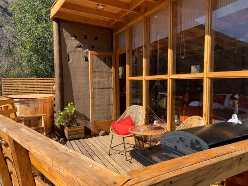eine Veranda eines Hauses mit einem Tisch und Stühlen in der Unterkunft Origen del Maipo Lodge in San José de Maipo