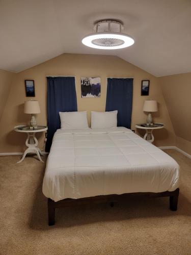 Schlafzimmer mit einem großen weißen Bett und blauen Vorhängen in der Unterkunft Cozy Country Home 