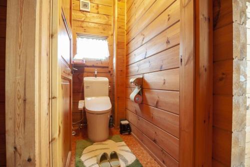 a bathroom with a toilet in a wooden wall at Log house Tomi-chan's house / Private building in Echizen