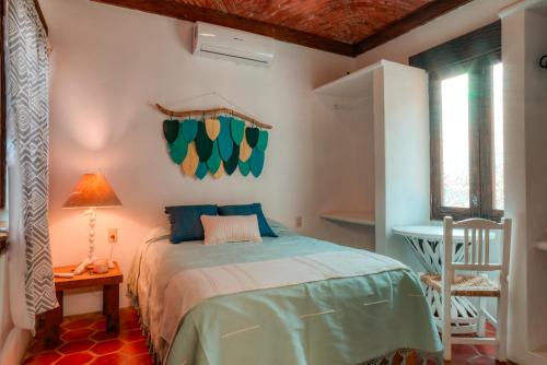 a bedroom with a bed and a table and a chair at Casa Hacienda in Sayulita