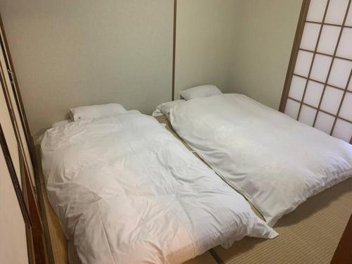 two beds sitting next to each other in a room at ステイビレッジ蔵王　一棟丸貸し宿泊施設4名様まで同一金額　ペット同伴可！ in To-katta