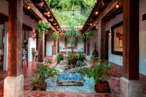 an indoor courtyard with plants and a fountain at Casa Hacienda in Sayulita