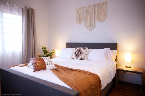 - une chambre dotée d'un grand lit avec des draps et des oreillers blancs dans l'établissement Tropical Villa Rainville, à Paramaribo