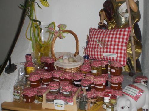 a table with bottles of honey and a basket of eggs at Haus Ploner - Pichlerhof in Chienes