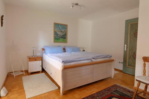 a bedroom with a bed with blue sheets on it at Ferienhaus Haas inkl. Chiemgaukarte in Ruhpolding