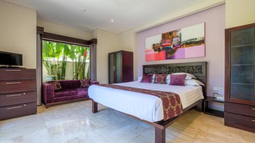 a bedroom with a large bed and a tv at Athena 2 Romantic 1br Pool Villa SANUR in Sanur