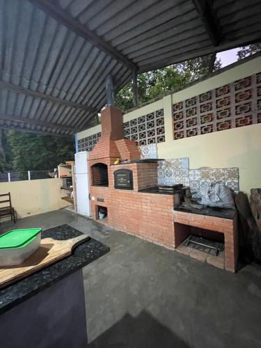 uma cozinha exterior com um forno de tijolos num pátio em Chácara Recreio São Luiz do Paraitinga em São Luiz do Paraitinga