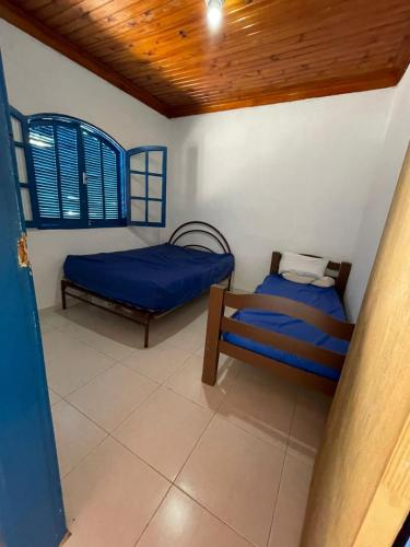 Cette chambre dispose de deux lits et d'un plafond en bois. dans l'établissement Chácara Recreio São Luiz do Paraitinga, à São Luiz do Paraitinga