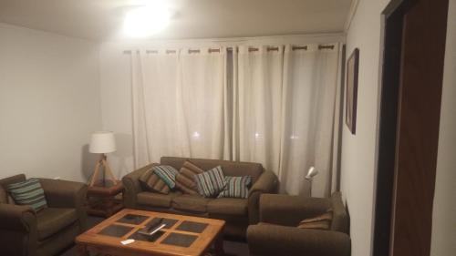 sala de estar con sofá y mesa de centro en Habitancion disponible en Vallenar