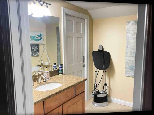een badkamer met een wastafel en een grote spiegel bij Serenity on the Shores in Portage