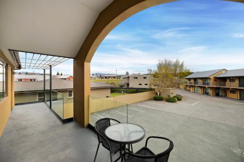 a patio with a glass table and chairs on a balcony at Avenue Motel in Alexandra