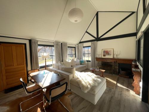 a living room with a white couch and a fireplace at The Cottage in Queenstown