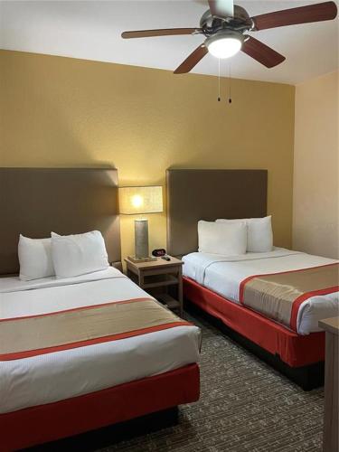 a hotel room with two beds and a ceiling fan at Floriday Resort in Orlando
