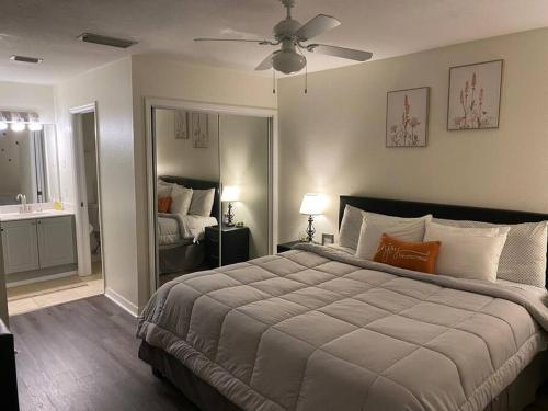 Un dormitorio con una cama grande y un espejo. en Disney Kissimmee Condo, en Kissimmee