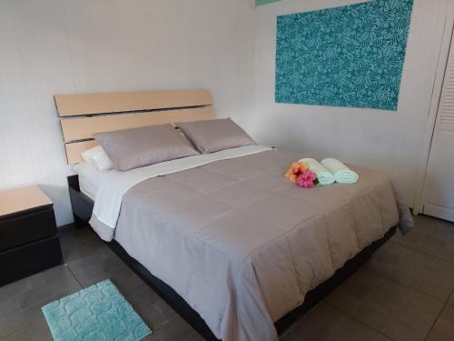 a bedroom with a bed with a bouquet of flowers on it at Cabañas Kitai in Hanga Roa