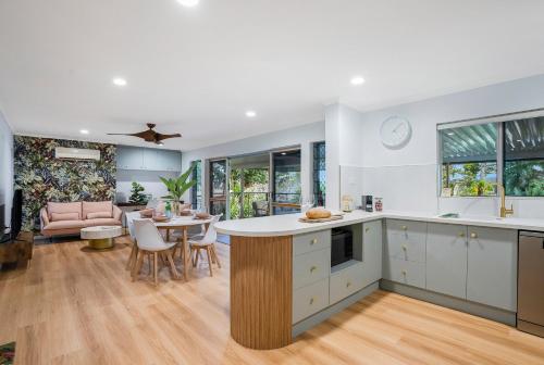 East TrinityにあるDeco View Family Oasis in Cairnsのテーブルと椅子のあるキッチンとリビングルーム