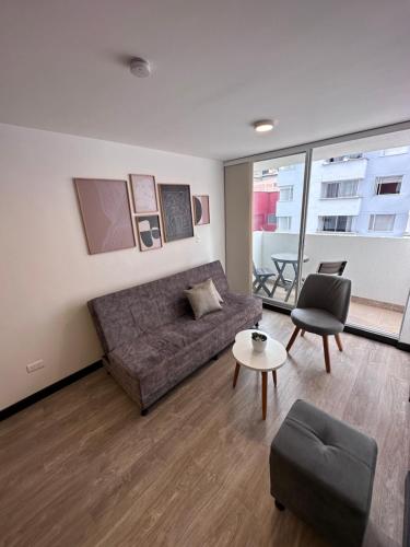 ein Wohnzimmer mit einem Sofa und einem Tisch in der Unterkunft Apartamento nuevo centro histórico! in Manizales