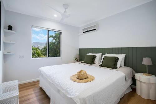 Deco View Family Oasis in Cairns في East Trinity: غرفة نوم مع سرير مع قبعة عليه