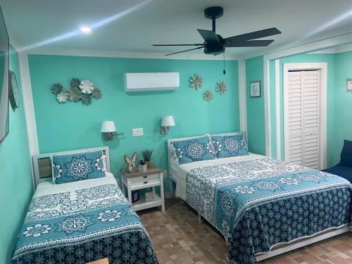 a bedroom with two beds and a ceiling fan at Beautiful and comfortable rom apt # 2 in Tampa