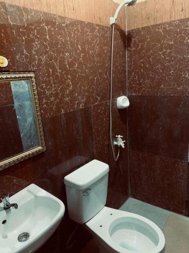 a bathroom with a toilet and a sink and a shower at SEACOAST HOTEL AND RESORTS in Mactan
