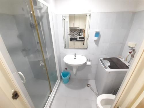 La petite salle de bains est pourvue d'une douche et d'un lavabo. dans l'établissement Sea Residences by EXIN, à Manille