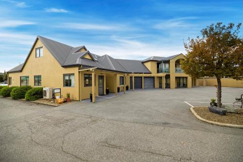 a large yellow building with a parking lot at Avenue Motel in Alexandra