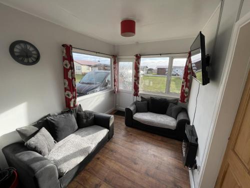 a living room with two couches and a tv at Captivating 2-Bed chalet in Bessingby