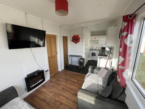 a living room with a couch and a flat screen tv at Captivating 2-Bed chalet in Bessingby