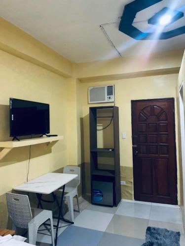 a room with a table and a television and a door at SEACOAST HOTEL AND RESORTS in Mactan
