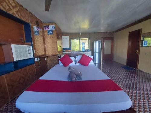 Cette chambre comprend un grand lit avec des oreillers rouges. dans l'établissement Bungalow Seaside Duplex, à Tunga