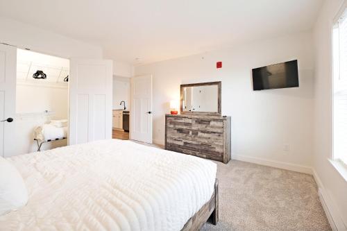 ein weißes Schlafzimmer mit einem Bett und einem Spiegel in der Unterkunft Idyllic & Cozy Stylish Belmont Haven near Lewiston - 1BR 1BA Apartment in Auburn