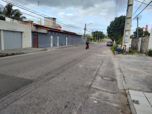 a person riding a motorcycle down an empty street at Casa Frida 3 in Natal