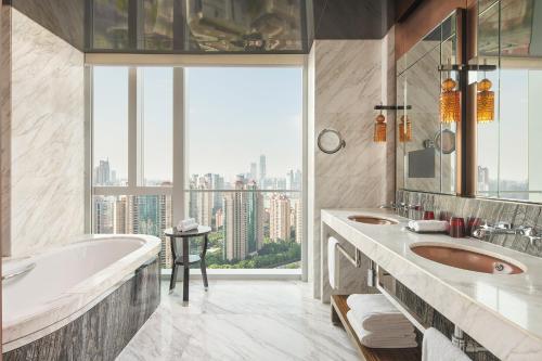 上海市にあるRegent Shanghai Pudong - Complimentary first round minibar per stay - including a bottle of wineのバスルーム(洗面台2台、バスタブ付)、窓が備わります。