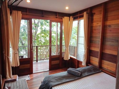 ein Schlafzimmer mit einem Bett in einem Zimmer mit Fenstern in der Unterkunft The Ocean Phangan Homestay in Haad Rin