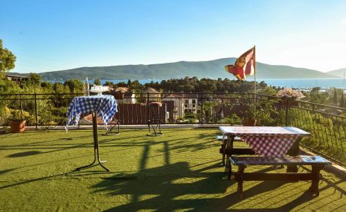a patio with a table and chairs and a flag at Hostel Anton in Tivat