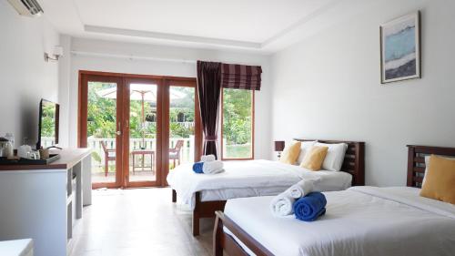 a hotel room with two beds and a balcony at Treeya Lanta in Ko Lanta