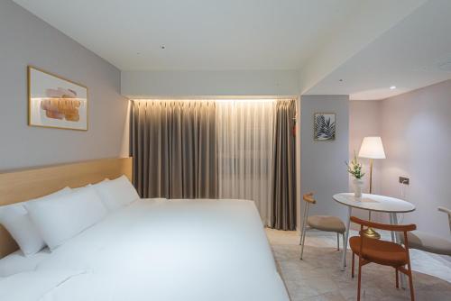 a hotel room with a bed and a table at Asherah Villa d' aqua Hotel in Gimhae
