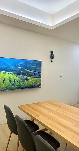 a meeting room with a wooden table and chairs at Hayano Stay in Tainan