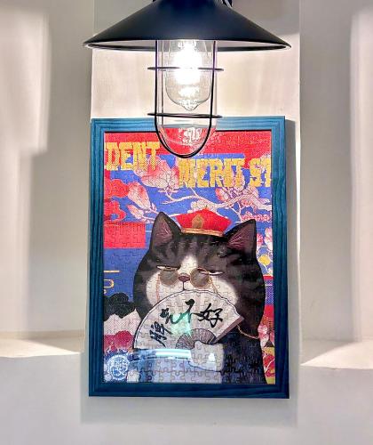a picture of a cat with a light above it at Hayano Stay in Tainan
