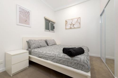 a white bedroom with a bed and a mirror at 22 Cooyou Close in Exmouth