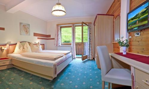 ein Hotelzimmer mit einem Bett und einem TV in der Unterkunft Gasthof zum Kaiserweg in Schladming