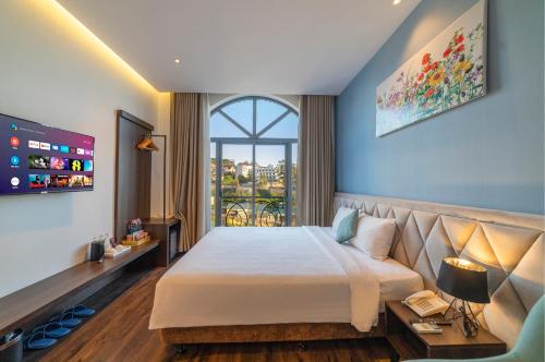 um quarto com uma cama grande e uma janela em Stillus Boutique Dalat Hotel em Da Lat