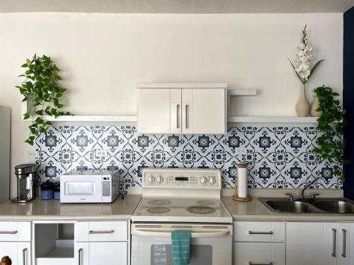 a kitchen with a white stove and a sink at El Depa de las Flores-300 m from the main blvd in San Carlos