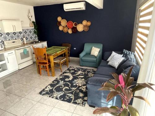 uma sala de estar com um sofá azul e uma mesa em El Depa de las Flores-300 m from the main blvd em San Carlos