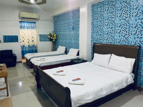 two beds in a room with blue tiles at SEACOAST HOTEL AND RESORTS in Mactan