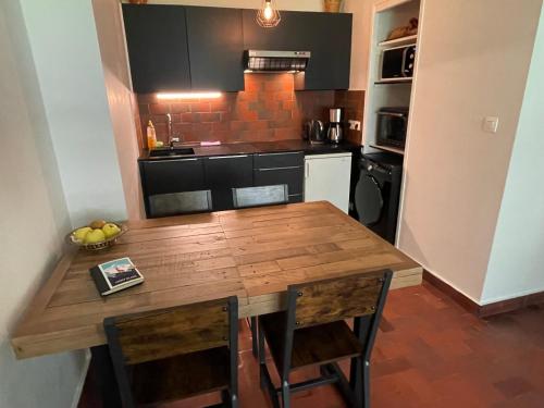 une cuisine avec une table en bois et quelques chaises dans l'établissement Résidence Bois du Bouchet, appartement vue montagne, calme, parking gratuit, proche centre, à Chamonix-Mont-Blanc